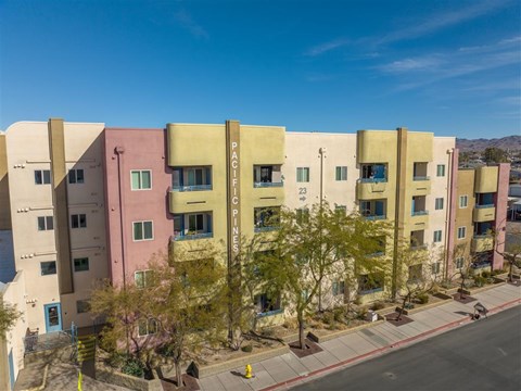 A street view of a row of multi-colored apartment buildings.
