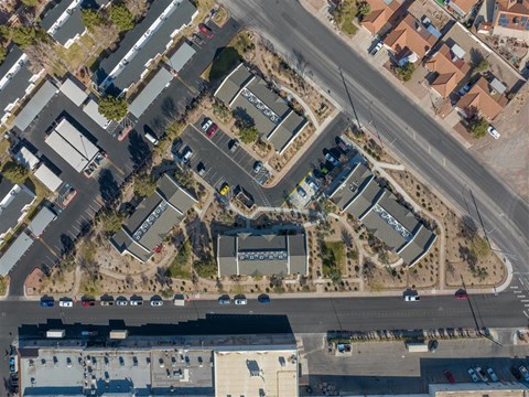 A bird's eye view of a road intersection with cars and buildings.