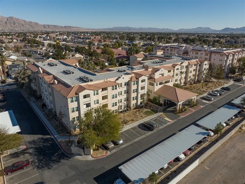 A large apartment complex with a parking lot in front.
