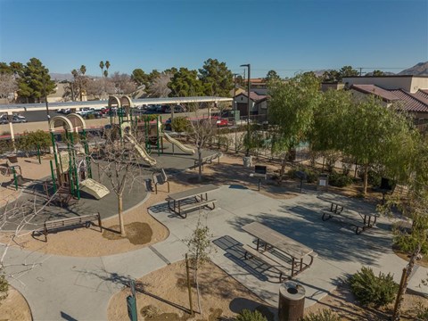 A playground with a slide, swings, and other equipment.