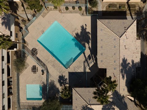 A swimming pool surrounded by a fence and trees.