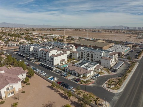 A large apartment complex with a parking lot in front.