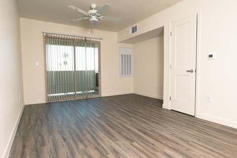 A room with a ceiling fan and a sliding glass door.