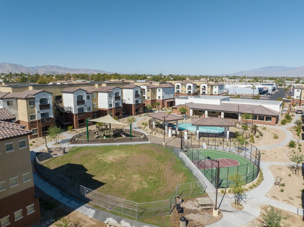 an aerial view of a park with a tennis court and buildings