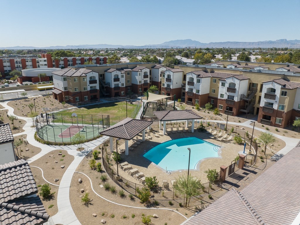 an aerial view of an apartment complex with a pool and tennis court