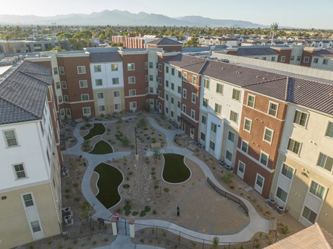 A courtyard surrounded by apartment buildings with a mountain in the background.