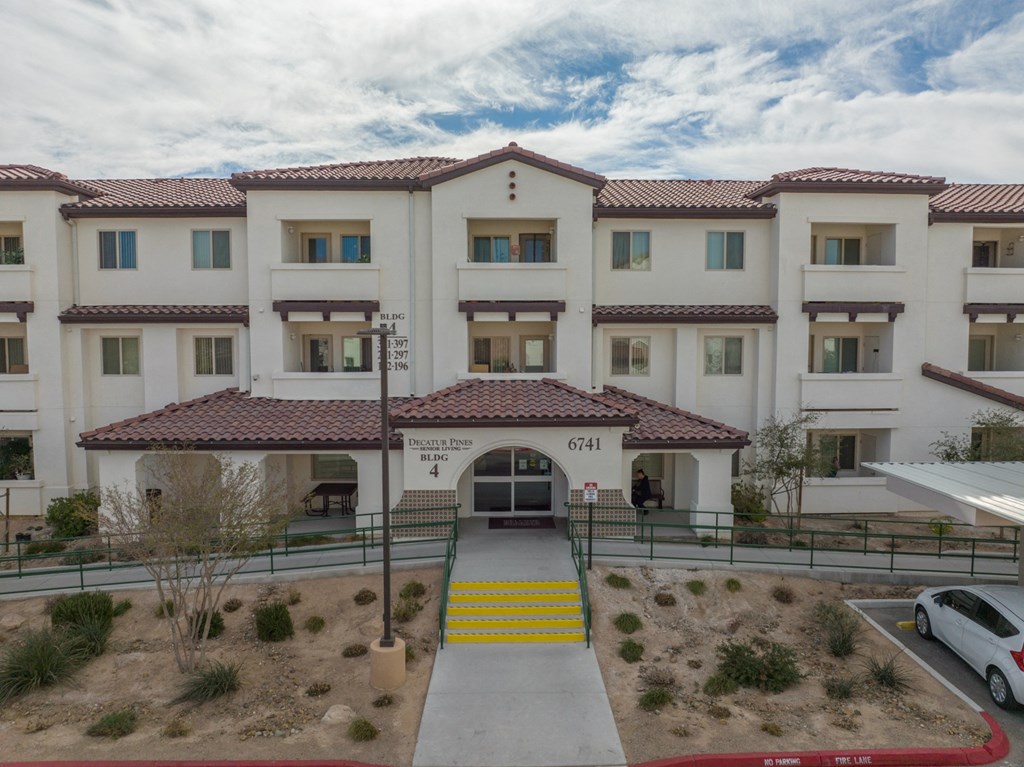 a view of the front entrance of a building with yellow stairs and a walkway