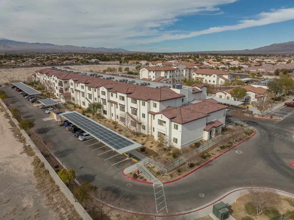 an aerial view of a building with solar panels in front of it