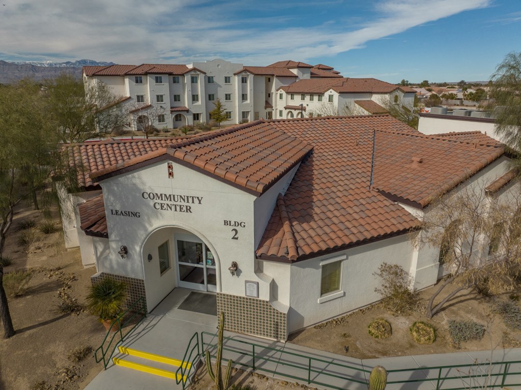 an aerial view of the community center building with apartments in the background