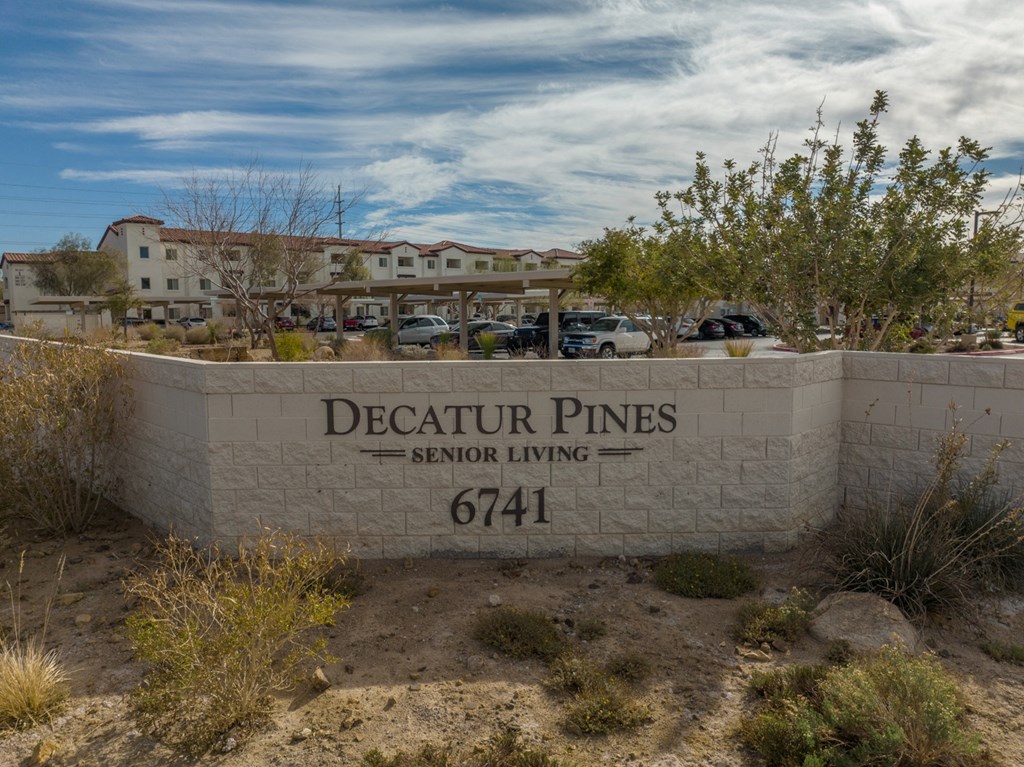 a stone wall with a sign that reads pines senior living 614