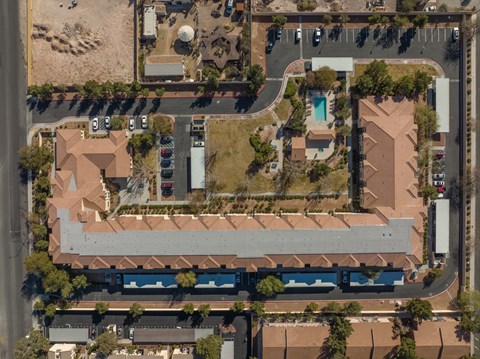 An aerial view of a building with a pool in the yard.