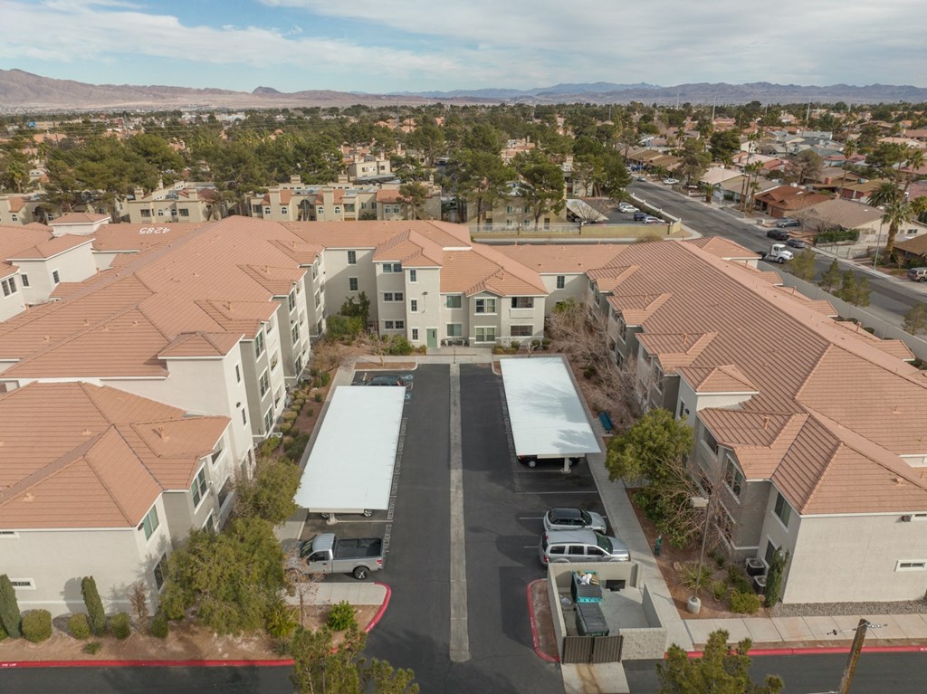an aerial view of an apartment complex with cars parked in a parking lot
