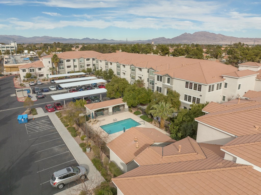 an aerial view of a building with a pool and parking lot