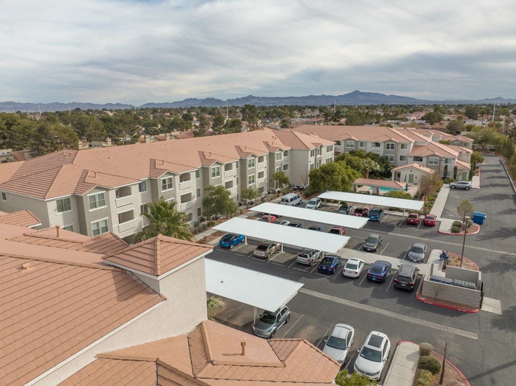 an aerial view of a parking lot with several apartment buildings and cars