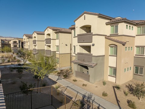 an aerial view of a row of apartment buildings with a gate and a street