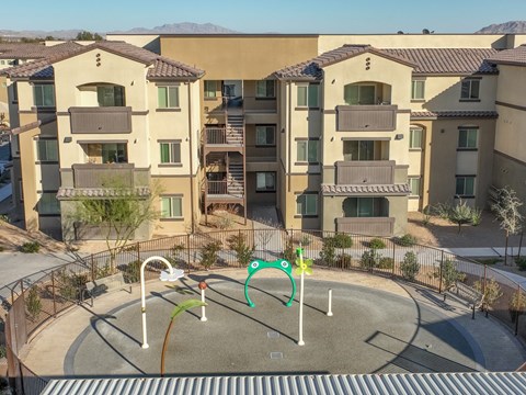 an aerial view of an empty playground in front of an apartment building