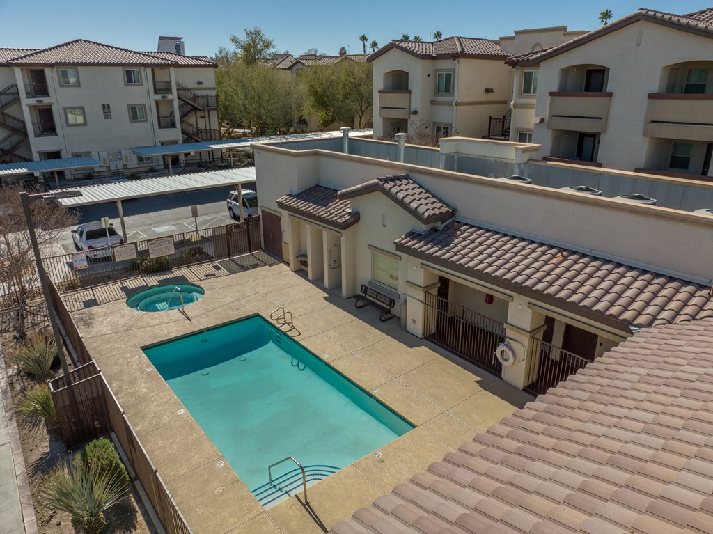 a view of the pool from the roof of an apartment building with a swimming pool