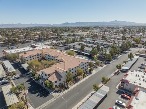 A bird's eye view of a town with a large white building with a red roof in the center.
