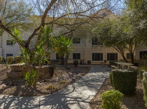 a courtyard in front of a building with trees and plants