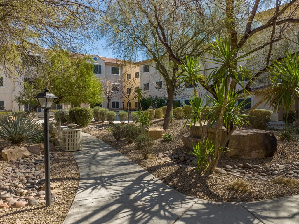 a pathway through a garden in front of a building