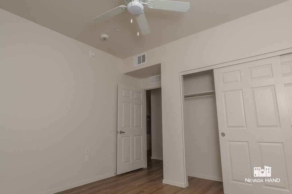 a bedroom with two closets and a ceiling fan