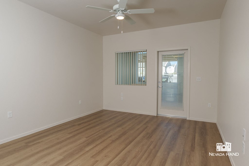 a spacious living room with a ceiling fan and wood flooring