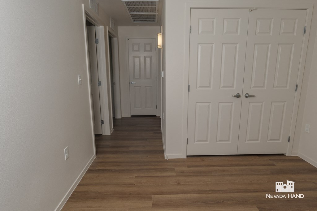 a hallway with white doors and a wood floor