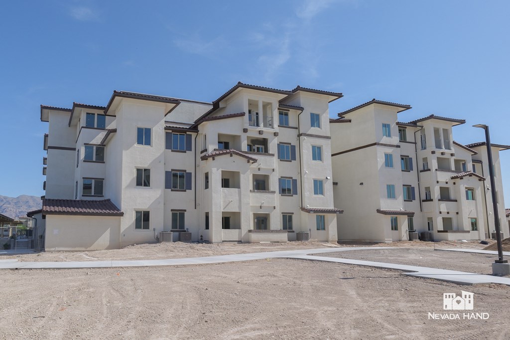 a row of apartment buildings on a dirt lot