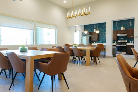 A modern dining room with a long table and chairs.