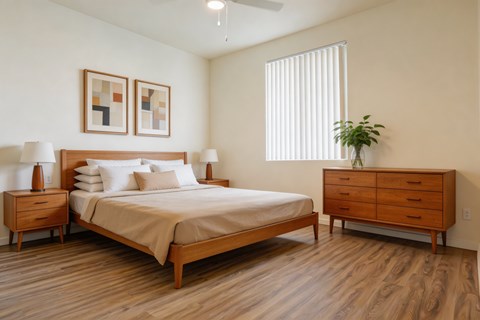 A bedroom with a bed, nightstands, and a plant.