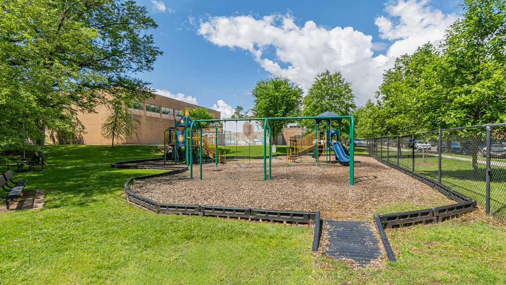 A playground with a green swing set and a slide at Eagles Crossing Apartments, Washington, DC, 20032