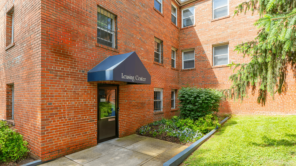 A brick building with a Leasing Center awning at Eagles Crossing Apartments, Washington