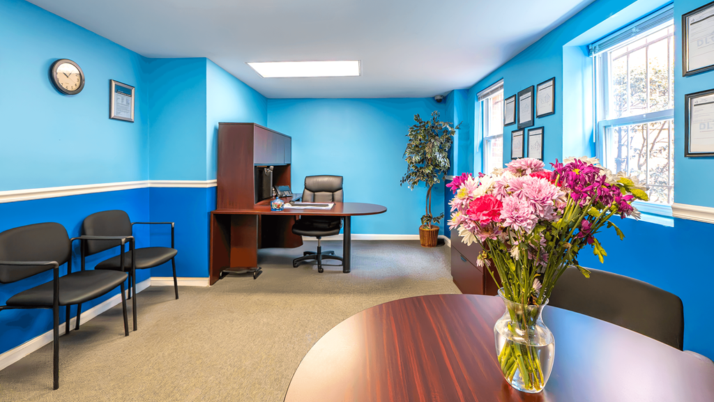 A conference room with a table, chairs, and a vase of flowers at Eagles Crossing Apartments, Washington DC