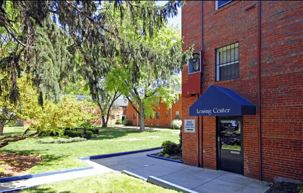 A brick building with a blue awning A brick building with a blue awning at Eagles Crossing Apartment , Washington