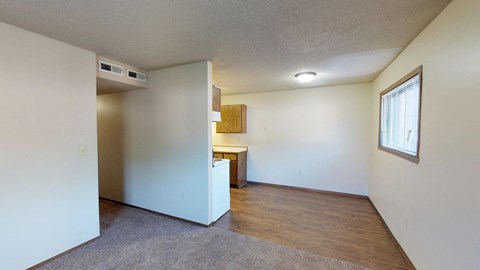 A room with a small kitchenette and a window.