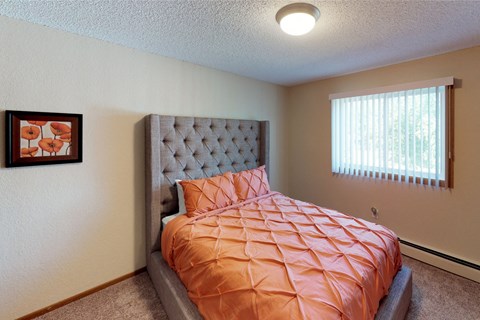 A bedroom with a bed and a picture on the wall.