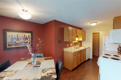 A kitchen with a table and chairs in front of a red wall.