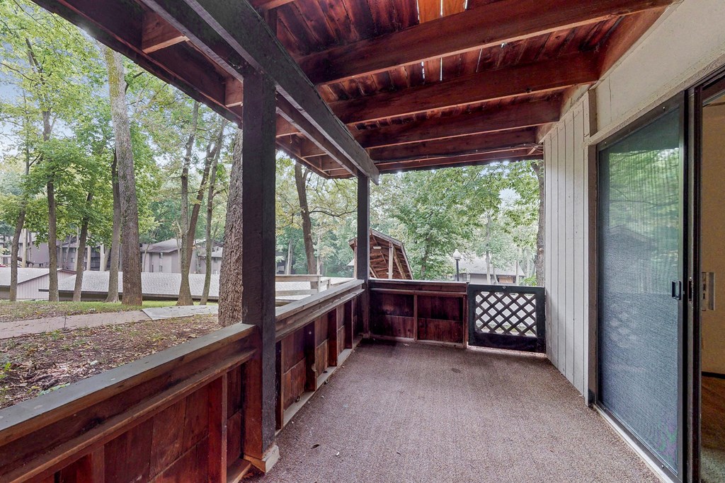 a covered porch with a view of the woods