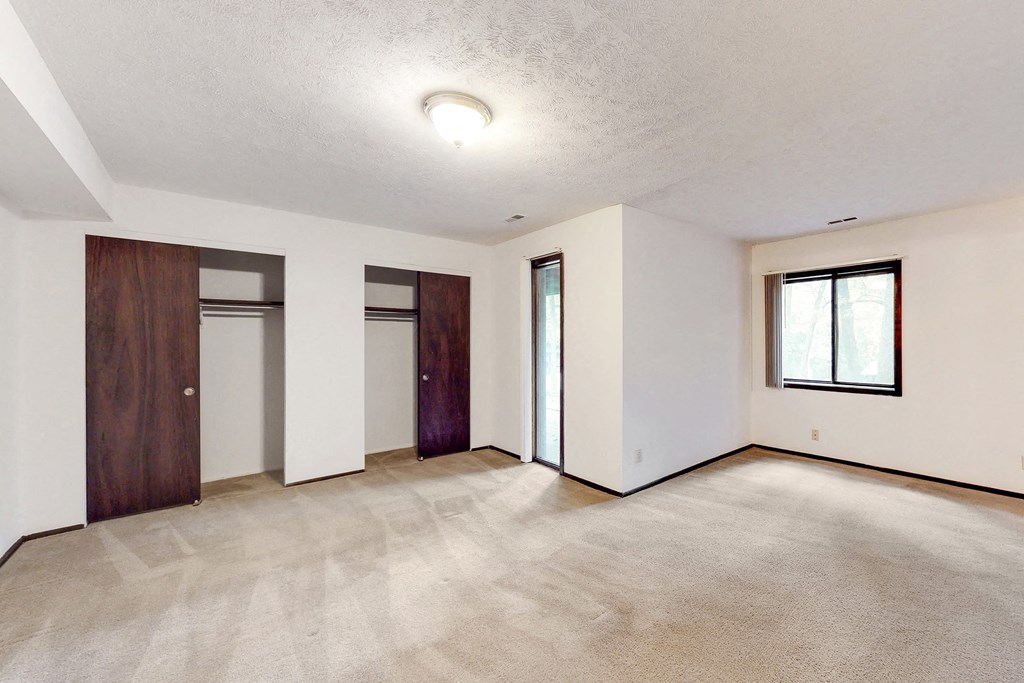 an empty living room with white walls and a wooden door