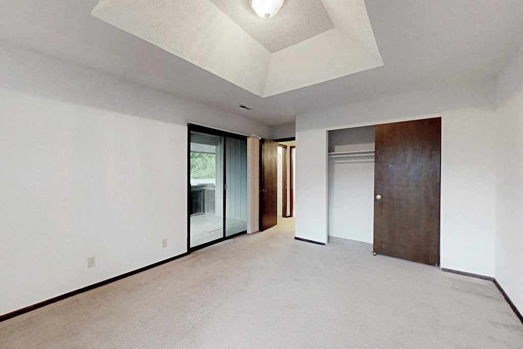 an empty room with white walls and a wooden door