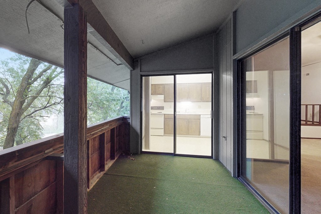 a long hallway with glass doors leading to a kitchen