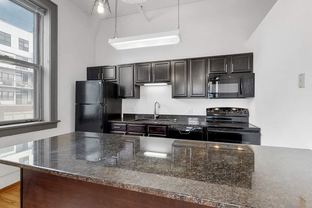 a kitchen with black appliances and granite counter tops