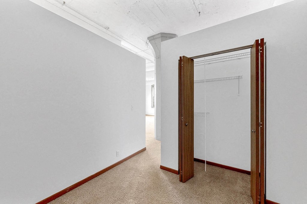 a room with a white wall and a door to a closet