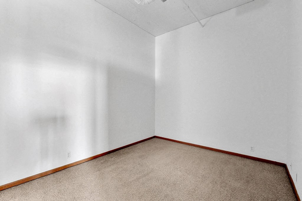 an empty room with carpet and white walls