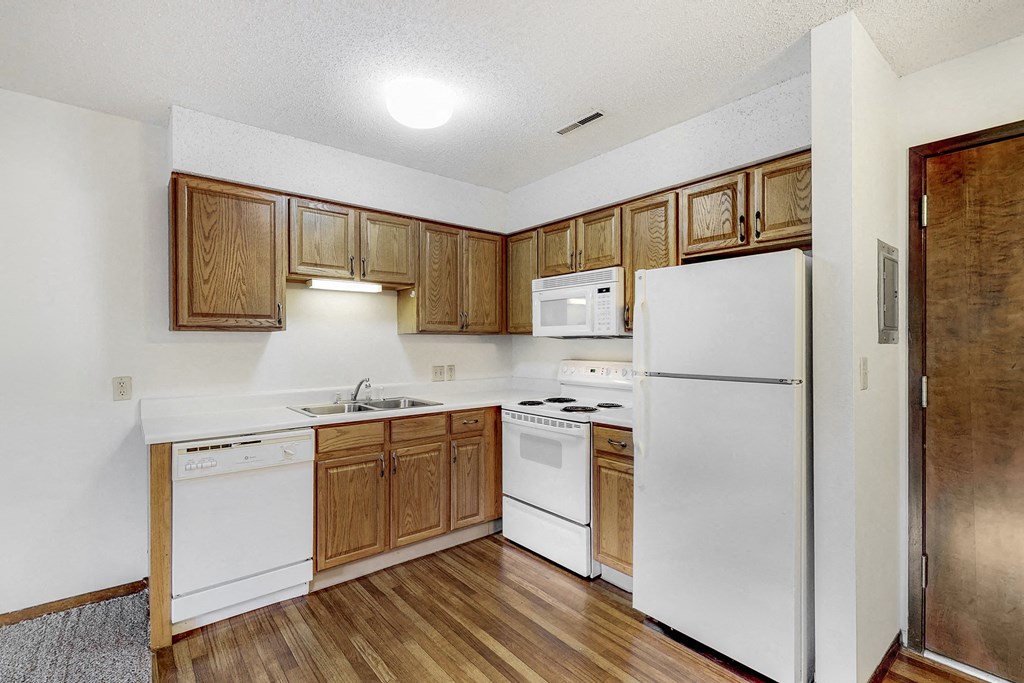a kitchen with white appliances and wooden cabinets
