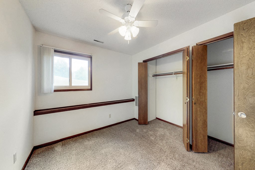 a bedroom with a closet and a ceiling fan