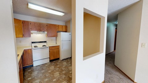 A kitchen with wooden cabinets and a white refrigerator.