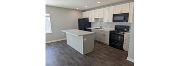 a kitchen with white cabinets and black appliances