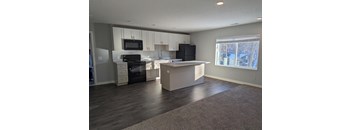 an empty kitchen with white cabinets and black appliances