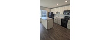 a kitchen with white cabinets and black appliances